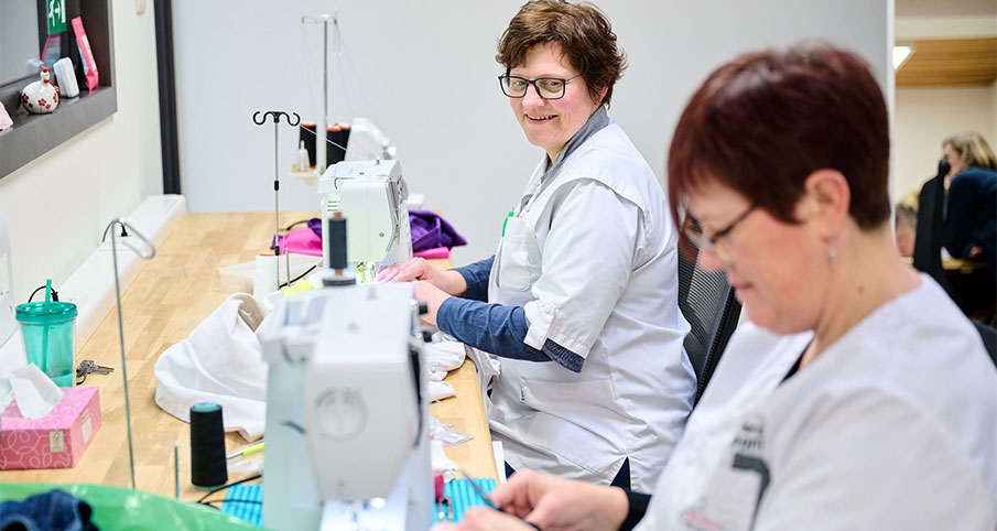 Deux travailleuses sont en train de coudre des vêtements dans l'Atelier du Linge