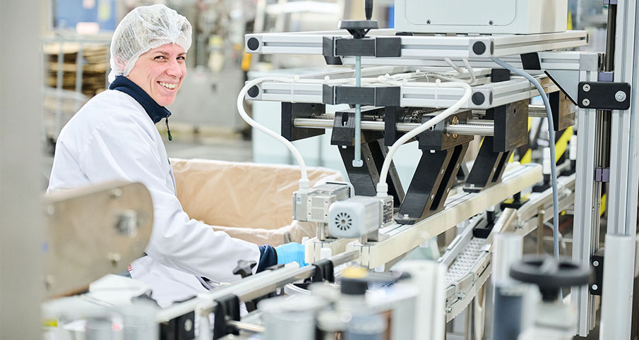 Une personne portant un équipement de travail qui travaille à proximité de machines automatisées au sein de la chaîne de production