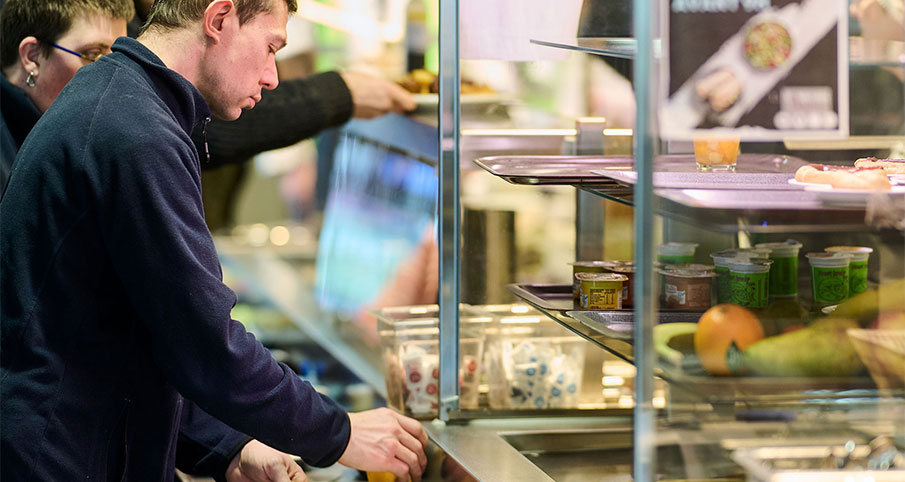 Un homme se sert au self-service pour manger à midi